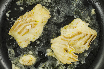 White cod on black frying pan