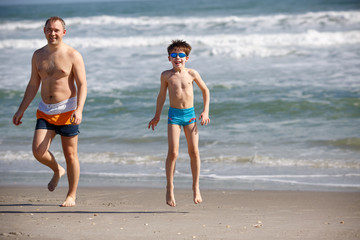 Young father and son playing on the beach