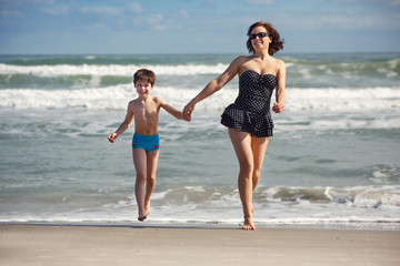 Young mother and son playing on the beach