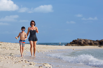 Young mother and son playing on the beach