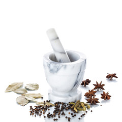 Marble mortar and pestle with assorted spices on white backgroun
