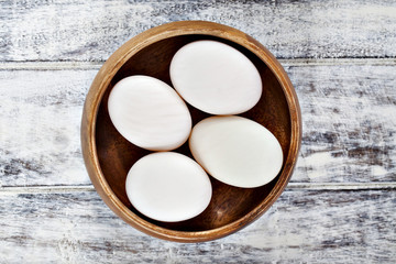 Duck eggs in brown wooden bowl