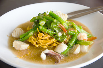 Fried noodle with pork and kale soaked in gravy - Stock Image