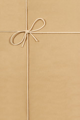 Brown paper package parcel background tied with string or rope photo vertical