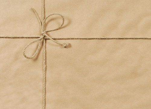 Brown paper package parcel background tied with string or rope photo