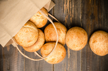 Homemade buns with paper bag on wooden background