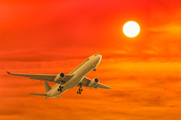 commercial airplane flying with sunset background