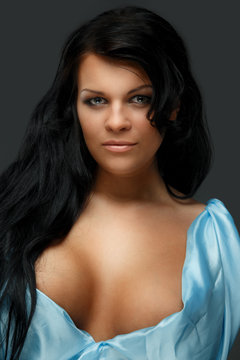 Portrait of dark haired woman in blue dress