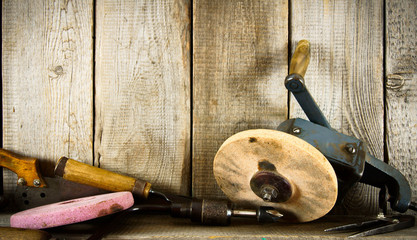 Many old tools ( pliers, circle and others) on a wooden shelf.