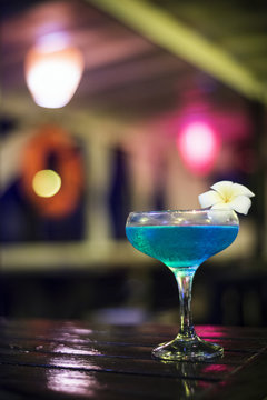 blue cocktail drink in dark bar interior