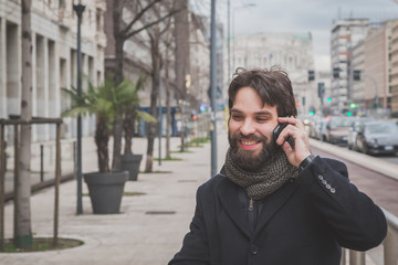 Young handsome bearded man talking on phone