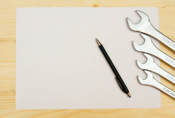 paper with the working tool on wooden background.