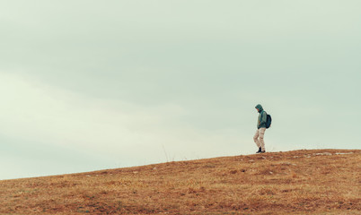 Fototapeta premium Hiker man walking down on the hill