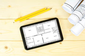 Fototapeta premium Tablet, drawings and pencils on a wooden background.