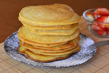 Stack of sweet pancakes with strawberry and icing sugar