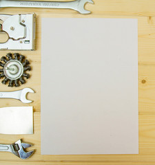 Paper for notes and set of working tools on wooden background.