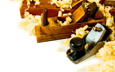 Joiner's works. Wooden shaving and plane on white background