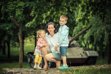 family on a background of an old vintage military tank