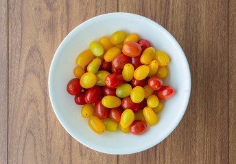 Red and yellow tomatoes in white bowl