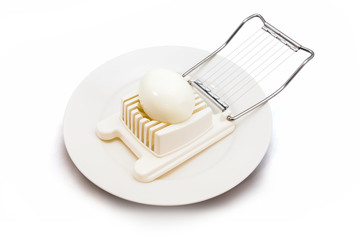 Boiled egg in an egg slicer isolated on white background