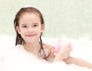 Smiling little girl washing in bath