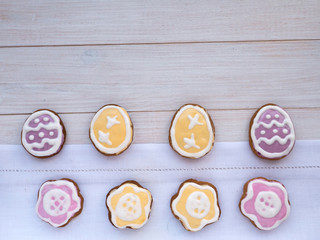 Fototapeta na wymiar Flower and egg shaped Easter cookies on the white wooden backgro