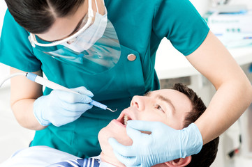 Obraz na płótnie Canvas Professional dentist doing teeth checkup