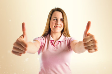 Young girl making Ok sign over white background