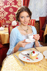 Girl in vintage dress in the restaurant. 