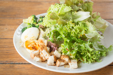 Homemade salad serving on wooden background
