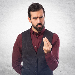 Man wearing waistcoat doing a money gesture