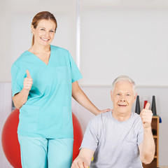 Physiotherapeut und Patient halten Daumen hoch