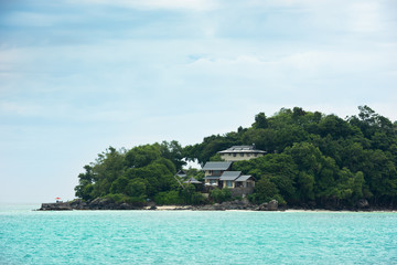 View of Seychelles coastline with houses in the forest