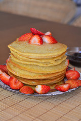 Stack of sweet pancakes with strawberry and icing sugar
