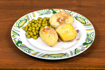 Boiled potatoes with green peas on a plate