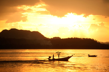 Naklejka na ściany i meble Sunset at traditional fishing boat in Koh Phitak island.