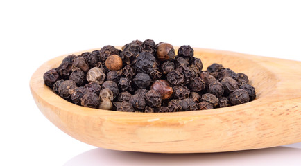 Black pepper on wooden spoon on  white background