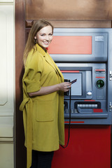 Blonde lady using an automated teller machine