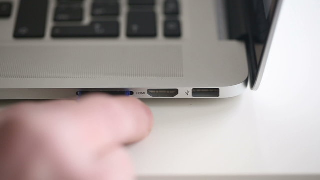 Hand inserting SD card 16Gb in memory card reader of notebook