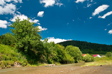 Fototapeta na wymiar Landscape with river, mountains and blue sky