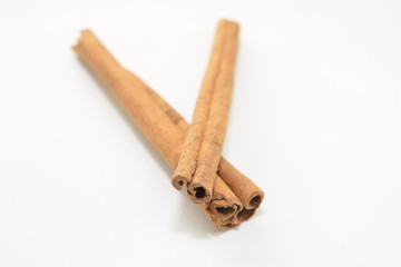 Cinnamon sticks stacked on white background.