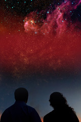 Fototapeta na wymiar Silhouettes of couple looking at stars. Starry night sky with