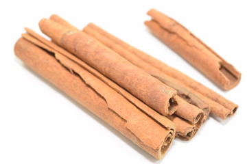 Cinnamon sticks stacked on white background.