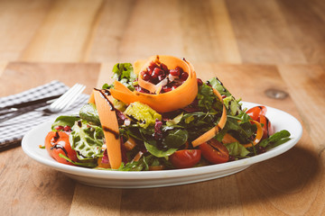 Salat auf kleinem Teller mit Messer und Gabel