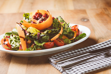 Salat auf kleinem Teller mit Messer und Gabel