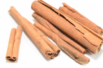 Cinnamon sticks stacked on white background.