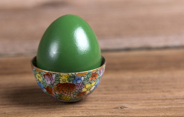 Green Easter egg in ornamented cup