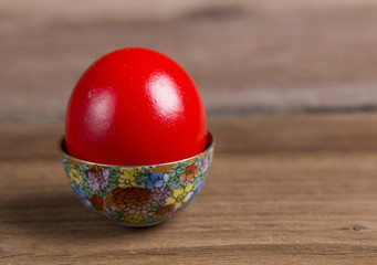 Red Easter egg in ornamented cup