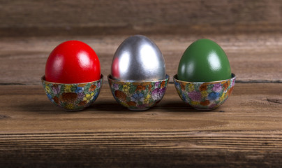 Colourful Easter eggs in ornamented cups