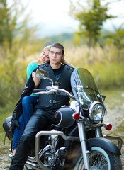 Fototapeta na wymiar Young couple with beautiful bike on road.